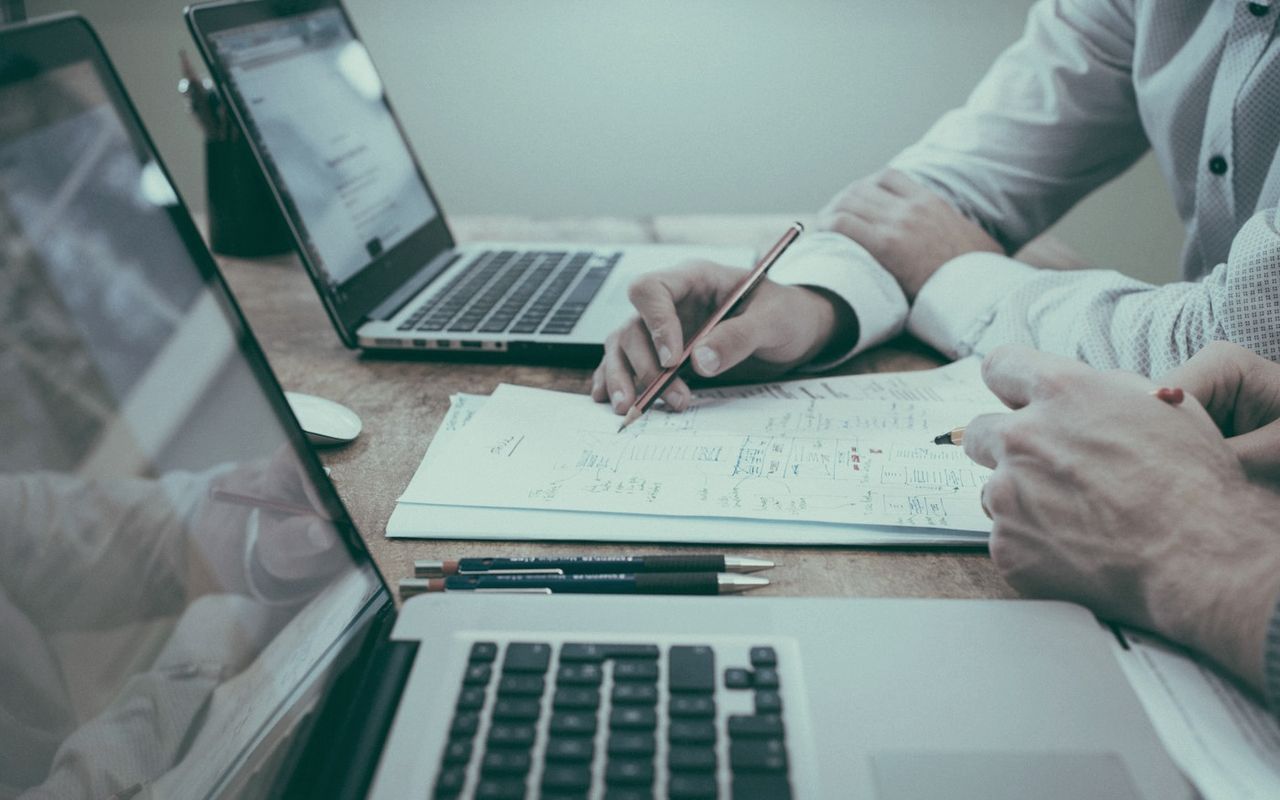 Notes, charts and a laptop laid out during business planning