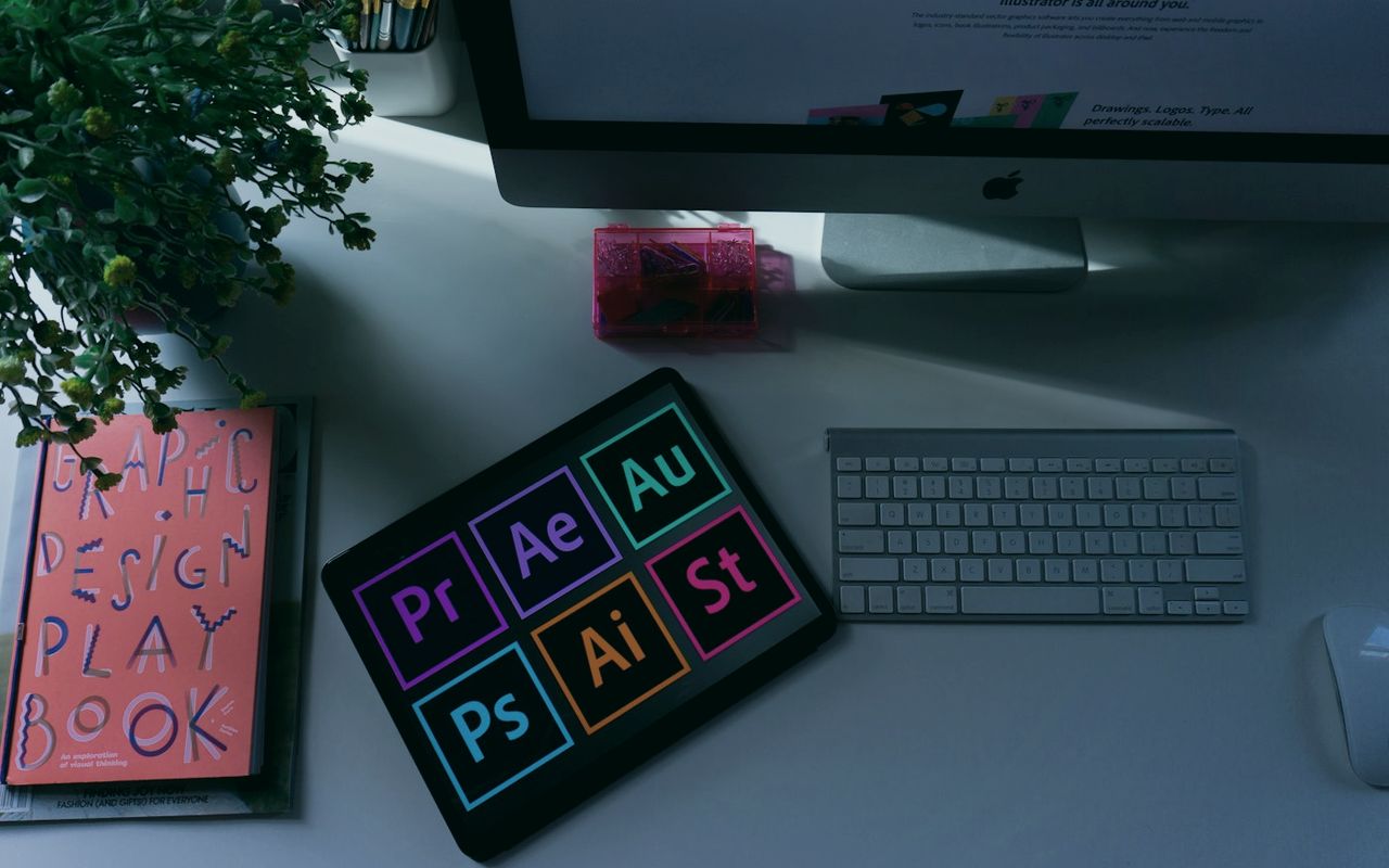 Design software icons glowing on a tablet beside a keyboard